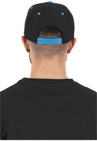 Cappellino nero con accenti blu, chiusura regolabile a scatto, caratterizzato da un design semplice e tessuto traspirante. Vista dal retro.