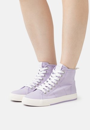 Zapatillas altas de color lavanda, elaboradas en lona, con cordones blancos, suelas de goma y ojales plateados. Con un lazo en la parte trasera.