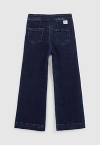 Jeans a gamba larga blu scuro in denim, con due tasche posteriori e un'etichetta cucita sulla vita. Vestibilità a vita media con dettagli a orlo grezzo.