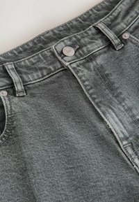 Grå denimjeans med en klassisk design, knäppning fram, fickor fram och subtila texturvariationer.