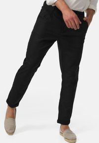 Sorte bukser med slim fit og oprevne bukseben, lavet af letvægts bomuldsstof, med forlommer og flad frontdesign.
