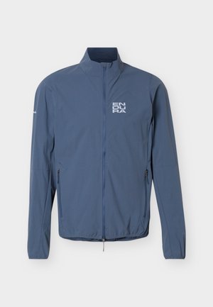 Kék, könnyű dzseki teljes hosszúságú első cipzárral, két cipzáras oldalzsebbel, valamint az "ENDURA" logóval a bal mellrészen és a jobb ujjrészen.