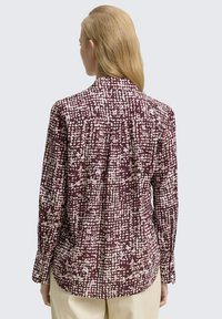 Langärmliges Hemd im abstrakten Design in Maroon und Hellrosa. Verfügt über einen Kragen, Knopfschluss und eine Rückenfalte für eine lockere Passform.