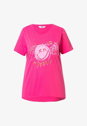 T-shirt di cotone rosa con una grafica a forma di faccina sorridente circolare e il testo "be happy" in lettere argentate riflettenti.