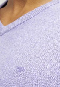 Licht lila V-hals trui, gebreide textuur, met een klein geborduurd logo op de borst, geribde halslijn, zachte en gladde stof.