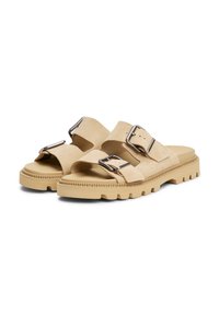Sandales en suède de couleur beige clair avec deux larges sangles et des boucles métalliques. Semelle en caoutchouc épaisse avec un motif de semelle pour une adhérence et une durabilité.