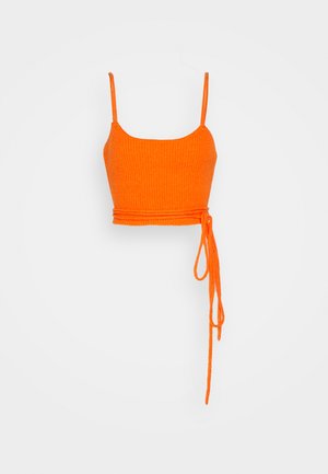 Top corto arancione a coste con spalline sottili e dettaglio in vita annodato. Il materiale sembra morbido con una finitura testurizzata.