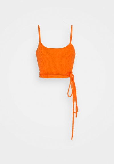 Πορτοκαλί ριμπ crop top με λεπτές τιράντες και λεπτομέρεια δέσιμου στη μέση. Το υλικό φαίνεται μαλακό με υφή.