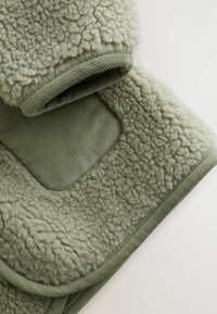 Green fleece garment with soft, textured surface, ribbed fabric accents, and smooth lining. Design features a cozy, oversized collar.