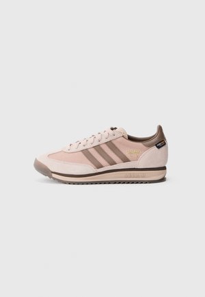 Baskets Adidas rose clair et marron avec panneaux en daim et mesh, trois bandes sur le côté et semelle en caoutchouc.