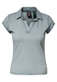 Camisa polo azul claro con un diseño de cuello, de mangas cortas y escote en V. Fabricada con un tejido suave con una textura sutil y detalle de logo.