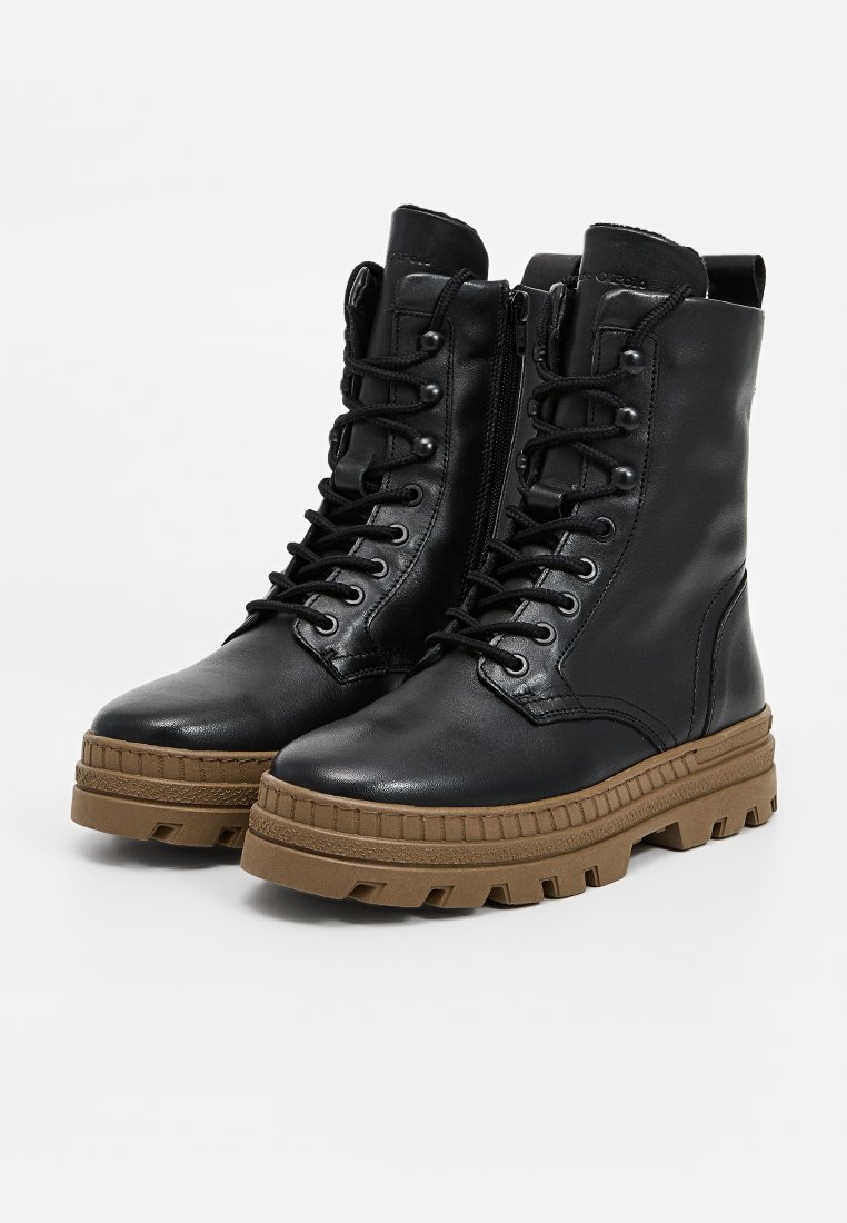 Schwarze Lederkampfstiefel mit einer klobigen braunen Sohle, mit Schnürsenkeln, seitlichem Reißverschluss und strukturierten Details im Obermaterial und an der Sohle.