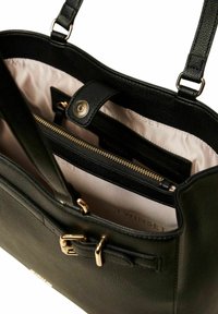 Borsa a mano in pelle nera con dettagli in oro, tasca con zip e fodera rosa chiaro; dotata di doppia tracolla, esterno texturizzato e chiusura a scatto.