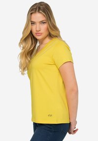 Geel V-hals t-shirt van zacht materiaal, met korte mouwen en een getailleerd ontwerp, voorzien van een klein logo nabij de zoom.