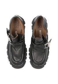 Zapatos de cuero negro con punta redondeada, suela de goma gruesa, detalle de hebilla en el costado y acabado texturizado. El interior es de cuero marrón.