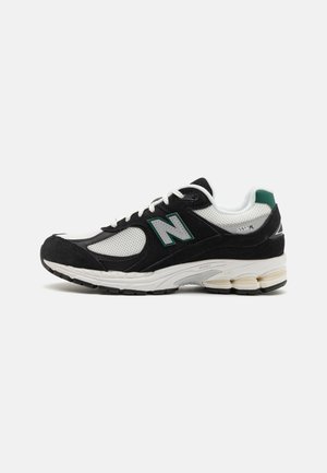 Czarno-biało-zielone buty sportowe New Balance 2002R z panelami z siateczki, zamszowymi nakładkami, sznurowaniem i amortyzowaną podeszwą do biegania.