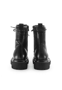 Stivali neri in pelle fino alla caviglia con suola spessa, tacco piatto e cerniere sui lati. Caratterizzati da linguette per una facile vestibilità. Texture liscia.