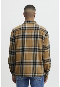Brown plaid flannel shirt with black and blue accents, long sleeves, and a buttoned cuff. Soft texture and standard collar design.