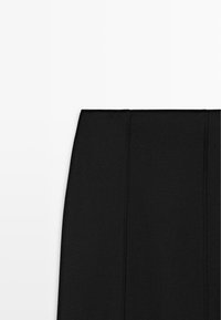 Black skirt with a straight silhouette, featuring seam details. Made from smooth fabric, with a clean, minimalist design and no pockets.