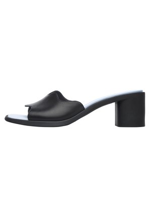 Sort mule sandal med åben tå, buet overdel og en kraftig blokhæl på hvid baggrund.