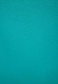 Ein einfarbiger türkiser Stoff mit glatter Textur und gleichmäßiger Rippung. Keine sichtbaren Muster oder Akzente vorhanden.