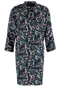 Robe-chemise à manches longues avec motif abstrait de feuilles vert foncé et noir sur fond rose clair, boutonnée sur le devant et avec col.