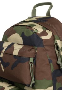 Zaino mimetico in verde oliva, marrone e crema con tasche con zip e tessuto testurizzato. Dotato di cordoncini regolabili e manico robusto.