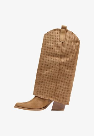 Tan suède cowboylaars halfhoog met geperforeerde schacht, puntige neus en gestapelde blokhak op witte achtergrond.