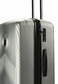 Silberner Hartschalenkoffer mit schwarzem Griff, Reißverschluss, ausziehbaren Griffen und integriertem TSA-Kombinationsschloss.