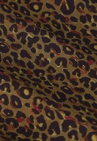 Tissu en imprimé léopard présentant des nuances variées de marron avec des taches marron foncé et des touches de bourgogne ; texture douce avec une finition légèrement brillante.