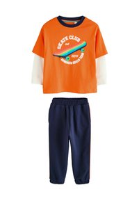 Oranges kurzärmeliges T-Shirt mit Skate-Grafik und marineblauen Sweatpants mit orangefarbenen Seitenstreifen, aus weichem Baumwoll-Mix-Stoff gefertigt.