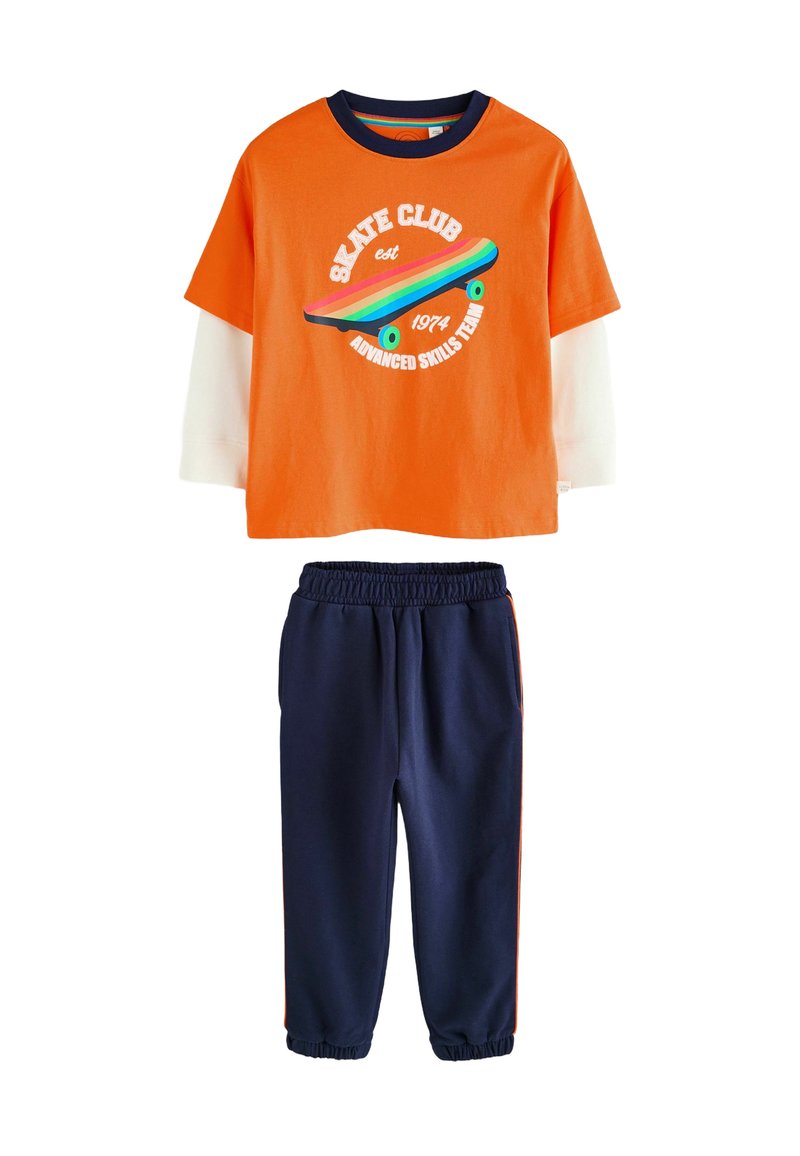 Oranges kurzärmeliges T-Shirt mit Skate-Grafik und marineblauen Sweatpants mit orangefarbenen Seitenstreifen, aus weichem Baumwoll-Mix-Stoff gefertigt.