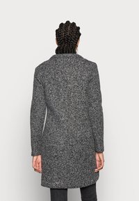 Abrigo de mezcla de lana gris con un acabado texturizado, mangas largas y cuello con muesca. Diseño de longitud media con una silueta ajustada.