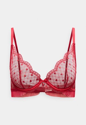 Lingerie en dentelle rouge avec tulle transparent, motifs en forme de cœur, bords festonnés, bretelles réglables et petit accent en forme de cœur au centre.