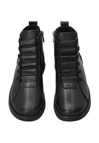 Černé kožené kotníkové boty mají texturovaný panel s elastickými detaily a bočními zipy pro snadné obouvání. Kulatá špička a gumová podrážka.