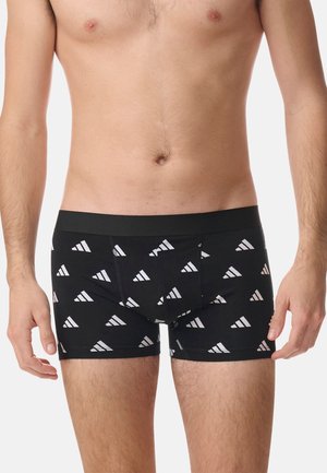 Boxer cortos negros con patrones triangulares blancos, material de algodón suave, cinturilla elástica y un diseño ajustado.