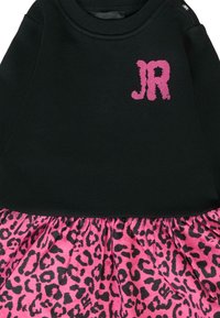 Czarna bluza z różowym logo "JR", połączona z plisowaną spódnicą w różowy leopardzi wzór. Elastyczny materiał i marszczony fason spódnicy.