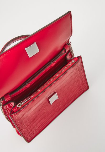 Red leather handbag with a crocodile texture, featuring a silver hardware closure, internal compartments, and a zippered pocket.
