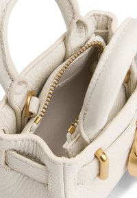 Λευκή δερμάτινη τσάντα χειρός με υφή, διακοσμητικά στοιχεία σε χρυσό μέταλλο, διπλές κοντές λαβές και φερμουάρ σε θήκη με λείο επένδυση.