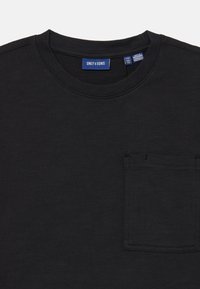 Črna kratka majica s kratkimi rokavi, izdelana iz mehkega blaga, s krožnim izrezom in žepom na prsih. Oznaka pravi "ONLY & SONS." Gladka tekstura.