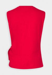 Top sin mangas rojo con cuello redondo y detalle fruncido en el lateral. Fabricado con una tela suave y lisa, con un corte holgado.