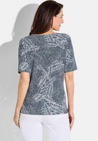 Korte mouwen top met een navy en witte bladenpatroon, gemaakt van zachte stof, met een relaxte pasvorm en ronde halslijn.
