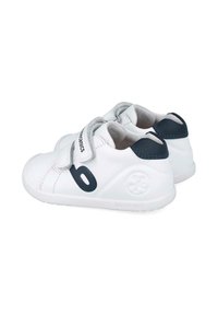 Zapatos de cuero blancos con un acento azul marino, que presentan una correa de velcro y un logotipo redondo en el talón. Suela de goma plana para mayor comodidad.