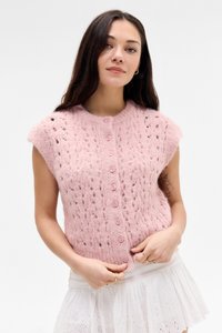 Rosa strikket vest med korte ermer, som har et teksturert mønster og seks knappelukking foran. Mykt, fluffy materiale med subtile detaljer.