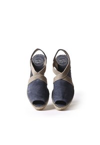 Námořnické espadrilky vyrobené z plátna s béžovými křížovými popruhy a otevřenou špičkou. Sól vyrobená z juty s texturovanými detaily.