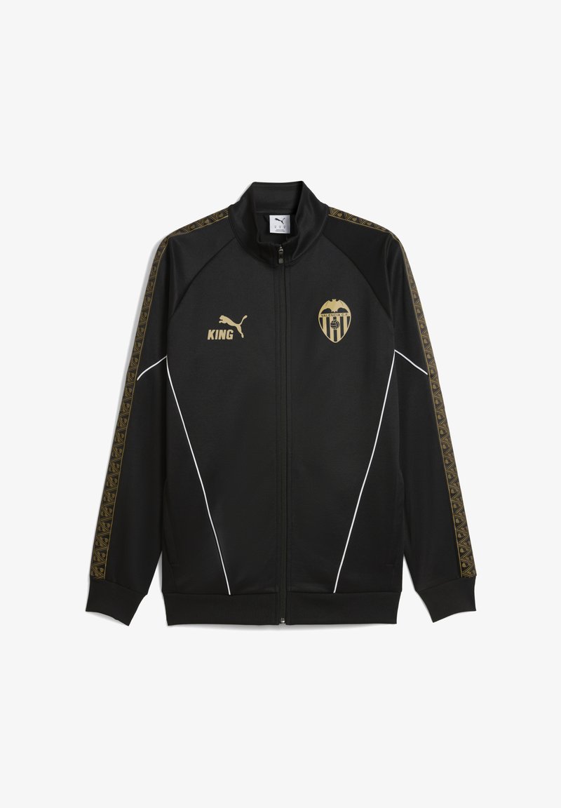 Svart zip-up jacka med guldaccent, med en logotyp och ordet "KING" i guld. Sidopanelerna har geometriska mönster. Vita kantdetaljer.