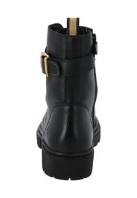 Botín de cuero negro con una hebilla dorada, acabado texturizado y una lengüeta dorada en contraste. Suela de goma resistente con un leve relieve.
