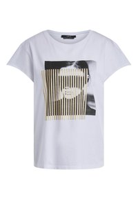 T-shirt blanc à manches courtes avec une photo en noir et blanc du visage d’une femme partiellement cachée par des bandes verticales dorées à l’avant.