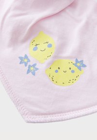Tessuto di cotone rosa con una trama liscia, caratterizzato da illustrazioni di limoni gialli e fiori blu, situato vicino al bordo con un orlo cucito.