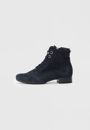 Bottines en cuir suédé bleu marine avec un bout arrondi, un laçage à l'avant et trois œillets. Talon bas et détails de surface texturés.
